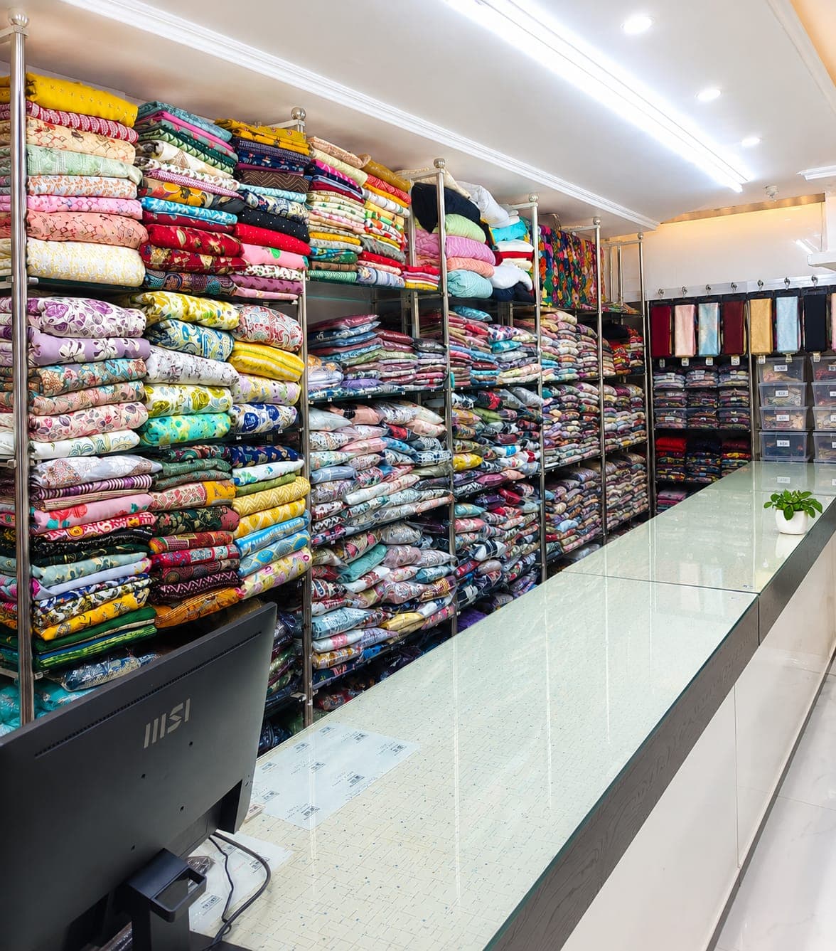 Wall of folded printed fabrics on display at Memon Cloth Store